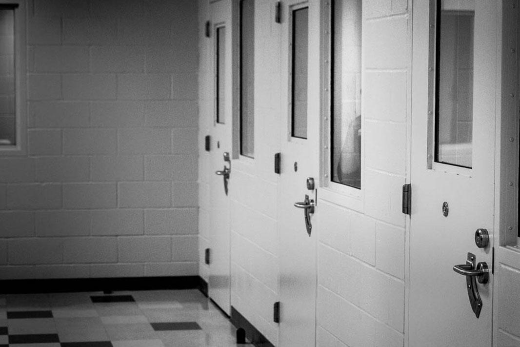 A young man peers out a window in a holding cell after arriving at the intake unit in juvenile hall. He got into a fight with a classmate at school and just learned he might have to spend the weekend in confinement.